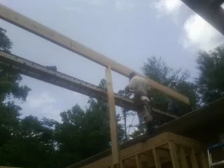 Carpenter setting a ridge beam over a new addition frame — Ice Dam Removal by Roofing Brothers in Eastsound